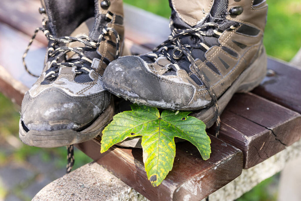 Zlomené turistické boty po podzimní túře na dřevěné lavičce - Fotografie, Obrázek