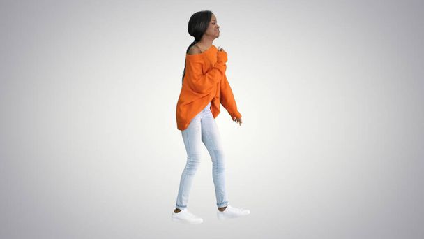 Young casual african woman dancing on gradient background. - Φωτογραφία, εικόνα