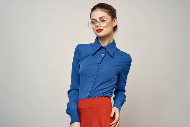 modelo de mujer en camisa azul y gafas de falda roja hermoso estudio de maquillaje facial - Foto, imagen