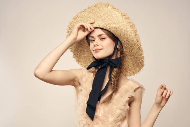 Nice girl in a straw hat with a black ribbon and in a dress on a light background romance model fun emotion - Fotó, kép
