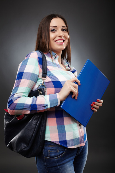 Smiling college student holding a notebook - 写真・画像