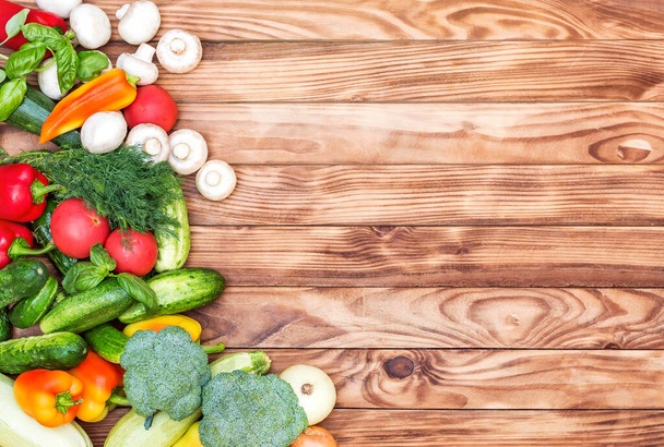 Border from different vegetables on wooden background. Top view. Space for text. - Photo, Image