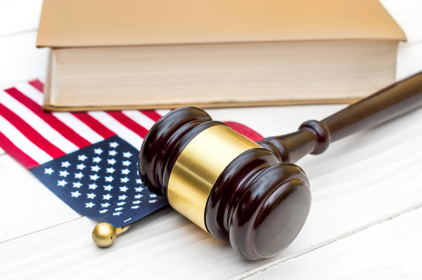 Martillo de juez con libro y bandera americana sobre mesa de madera blanca. - Foto, Imagen