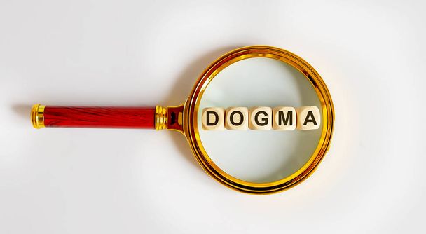 Holzblöcke mit dem Text: DOGMA auf Lupe. - Foto, Bild