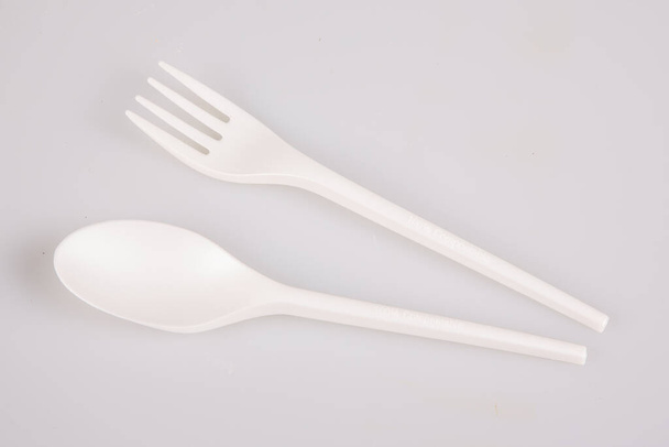 tenedor y cuchara blanco desechable reciclable aislado sobre fondo superficial - Foto, Imagen