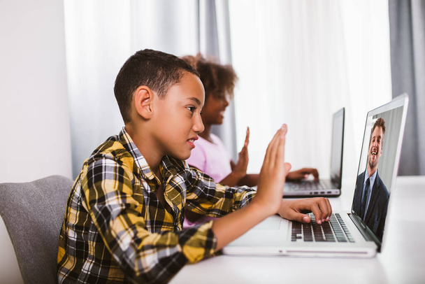African American elementary students using computer and following classes online due to coronavirus pandemic. - Photo, Image