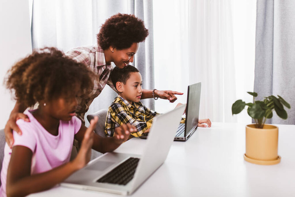 Afrika kökenli Amerikalı ilkokul öğrencileri koronavirüs salgınından dolayı bilgisayar kullanıyor ve derslerini internetten takip ediyor. - Fotoğraf, Görsel