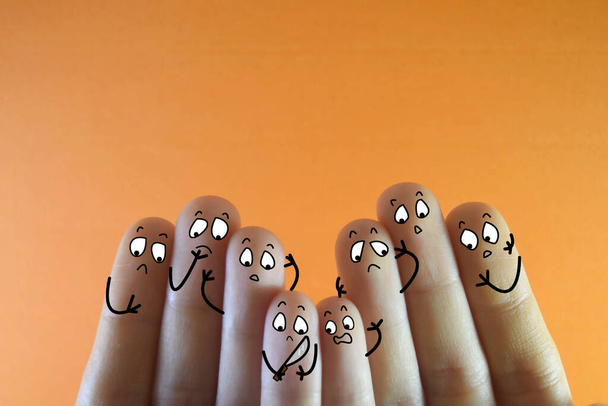Eight fingers are decorated as eight person. One of them is holding a knife and he is depressed. - Photo, Image
