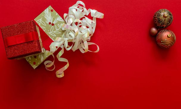 Weihnachten Hintergrund mit Geschenkschachteln und Dekorationen auf rot. Vorbereitung auf die Ferien. Draufsicht mit Kopierraum. - Foto, Bild