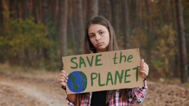 Девушка-подросток с плакатом "Спаси планету" - Кадры, видео