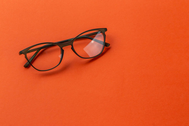 Glasses for sight in olive frames on an orange background. Fashion accessories. - Foto, Imagem