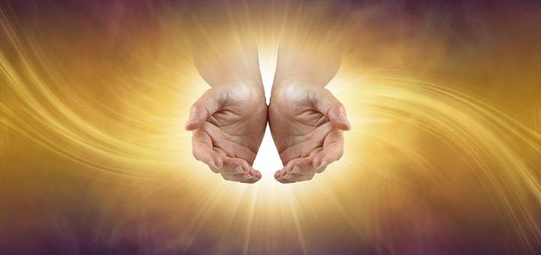 Высокая вибрационная энергия исцеления всегда доступна - только спросите - женские руки в мешке светятся белым светом на золотом фоне с копировальным пространством - Фото, изображение