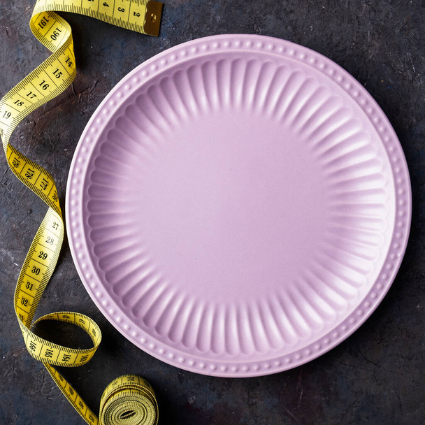 Пустая тарелка и скотч. Концепция диетического питания. Вид сверху. Крупный план - Фото, изображение