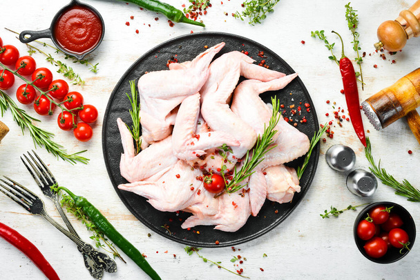 Raw chicken wings with spices on a kitchen background. Meat. Top view. Rustic style. - Fotoğraf, Görsel