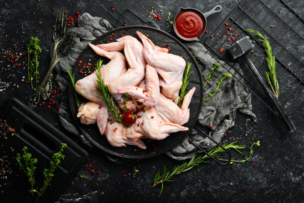 Raw chicken wings with spices on a kitchen background. Meat. Top view. Rustic style. - Zdjęcie, obraz