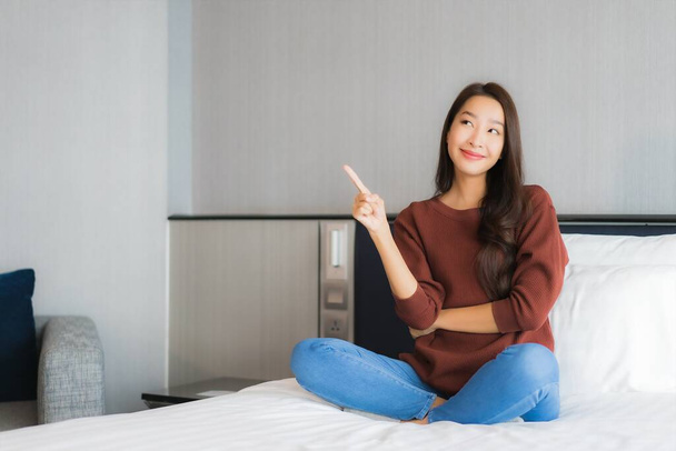 Retrato bonito jovem asiático mulher relaxar na cama no quarto interior - Foto, Imagem