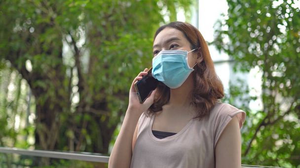 Asijské žena mluví pomocí mobilního telefonu pracuje z domova během Coronavirus nebo Covid-19 karantény - Fotografie, Obrázek
