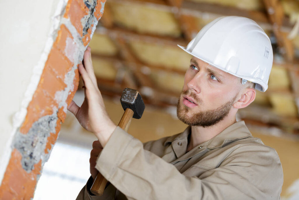 a builder with a hammer - Фото, изображение