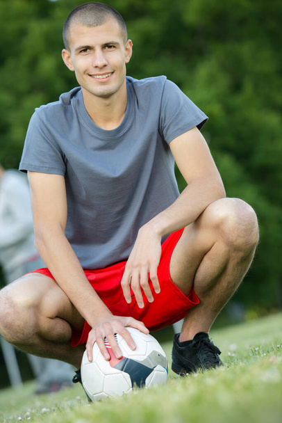 young football player excited happy kneeling on grass - Photo, image