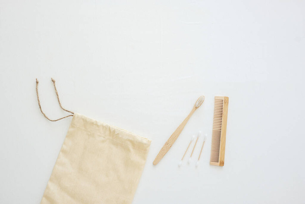 Eco bag, Bamboo Toothbrush, cotton bud and comb on white bed background. Environmental Protection, Zero waste, Reusable, Plastic free, World Environment day and Earth day concept - Photo, Image
