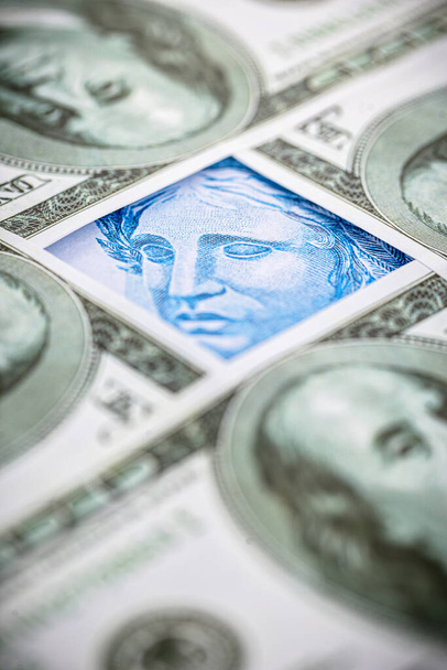 Brezilya 'dan gelen 100 reais banknotun ayrıntıları. 100 Amerikan dolarının banknotları arasında sıkıştı. Ekonomik kriz ve Amerikan para biriminin yükselişi - Fotoğraf, Görsel