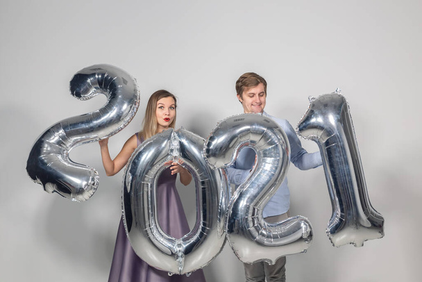 Party, people and new year holidays concept - woman and man celebrating new years eve 2021 - Foto, Imagen