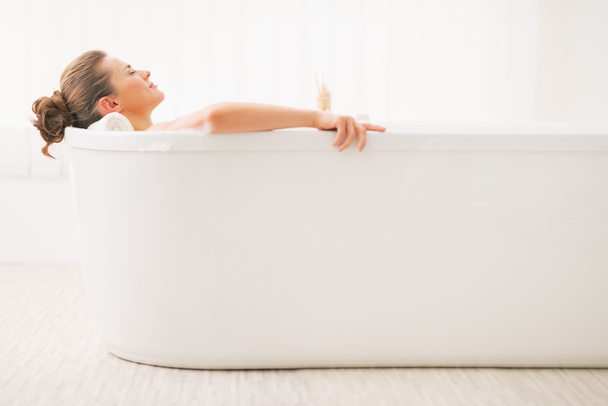 Relaxed young woman laying in bathtub - Фото, зображення