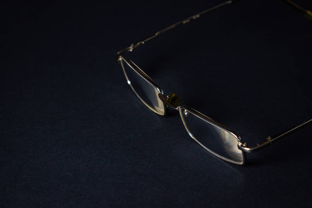 Glasses on a black background. Elegant style. There is a place for an inscription or logo. - Foto, Bild