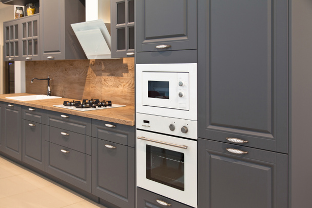 Интерьер роскошного современного кухонного оборудования и серых шкафов - Фото, изображение