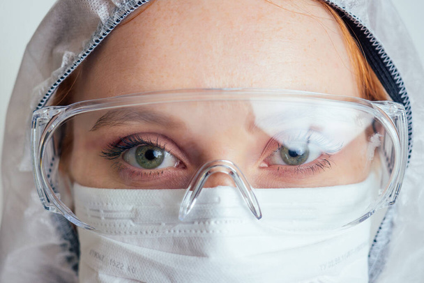 virologist woman in chemical protection mask ,glasses and gloves holding potential vaccine at the lab - Фото, зображення