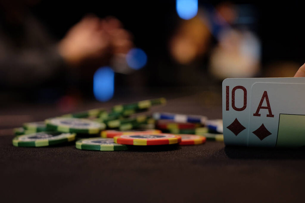 Dealer or croupier shuffles poker cards in a casino on the background of a table, chips. Concept of poker game, game business. Playing for money, a big win, a jackpot, gambling, a desire to get rich. - Fotó, kép