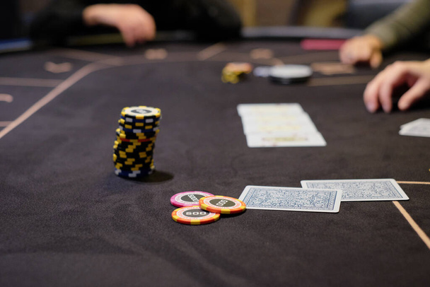 Dealer nebo krupiér míchá pokerové karty v kasinu na pozadí stolu, žetony. Koncept pokeru, herní byznys. Hraní o peníze, velká výhra, jackpot, hazard, touha zbohatnout. - Fotografie, Obrázek
