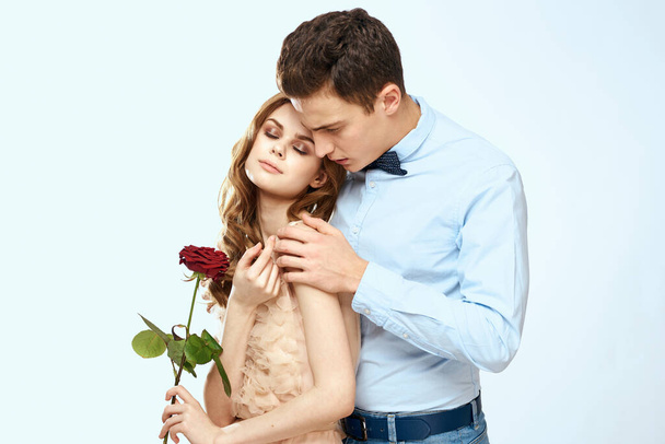 jong paar knuffels romantiek dating lifestyle relatie licht achtergrond rood roos - Foto, afbeelding