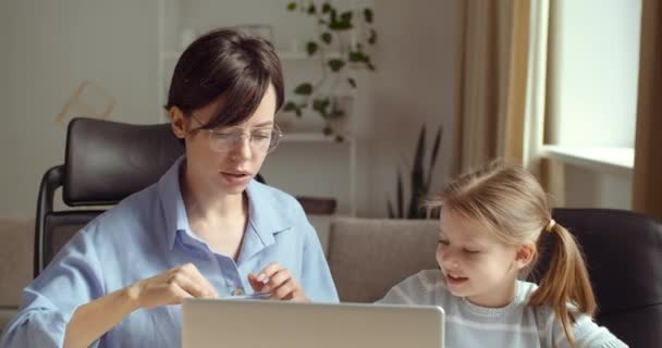 Babysitter femme fait des devoirs avec la petite dame à l'ordinateur portable, soeur aide la fille préscolaire à dessiner, mère passe du temps avec sa fille à l'ordinateur, enseigne à l'enfant à la maison, temps de quarantaine apprentissage électronique - Séquence, vidéo