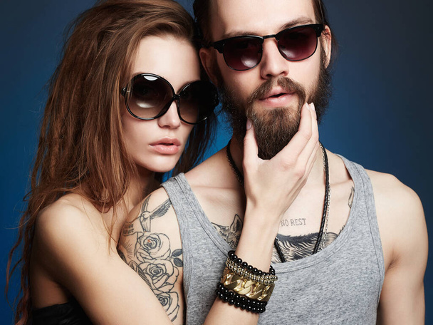 fashion beautiful couple in sunglasses. bearded Hipster boy and beauty girl with tattoo - Фото, зображення