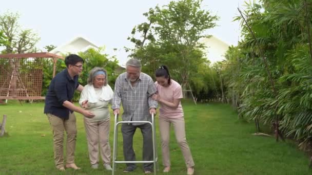 De oude man liep met een wandelaar in de achtertuin, met een gezin met een vrouw, dochter en zoon om te onderhouden, totdat hij alleen kon lopen zonder een wandelaar om te helpen met.  - Video