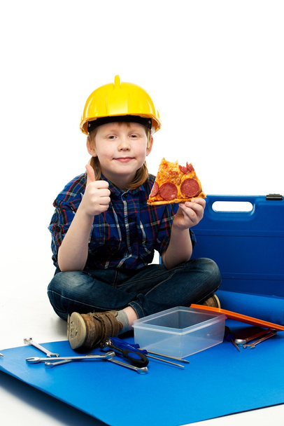 Маленький смішний механічний хлопчик їсть піцу серед інструментів
  - Фото, зображення