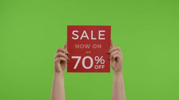 Sale Now On Up To 70 Percent Off inscription on paper sheet in womans hands on chroma key - Photo, Image