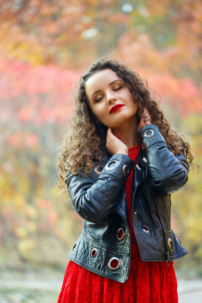 秋の公園でカールを持つ美しい女の子 - 写真・画像