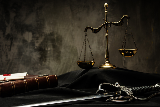 wagi, książki i miecz sprawiedliwości na sędziego w płaszcz - Zdjęcie, obraz