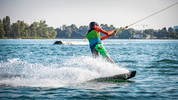 Hombre wakeboarder siendo tirado en un lago - Foto, Imagen