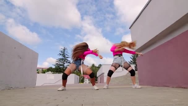 Duet van jonge vrolijke vrouwen dansen gratis stijl straat dansen, hiphop choreografie buiten in de stad. Langzame beweging - Video