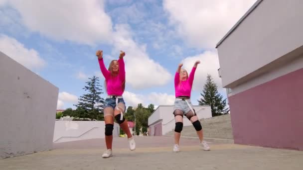Duet van jonge vrolijke vrouwen dansen gratis stijl straat dansen, hiphop choreografie buiten in de stad. Langzame beweging - Video
