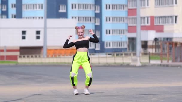 Yüksek binaların arka planında hip hop dansı yapan genç bir kadının videosu. Yavaş çekim - Video, Çekim