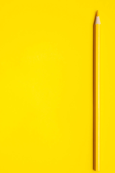 vertical yellow sharp wooden pencil on a bright yellow background, isolated, copy space, mock up - Photo, Image