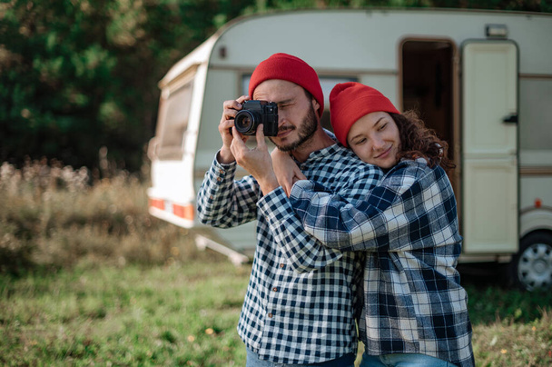 Romantisches Paar mit Kamera in der Natur in der Nähe des Wohnwagens. - Foto, Bild