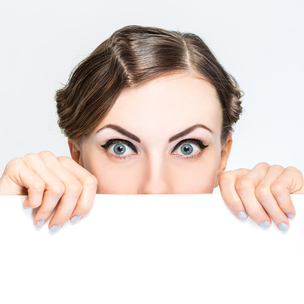 Woman peeking out from behind billboard paper poster - Photo, Image
