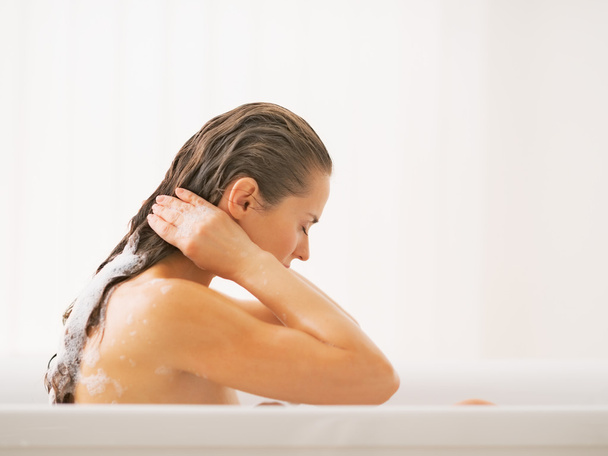 Young woman washing hair in bathtub - Φωτογραφία, εικόνα