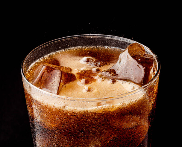 Παγωμένη δροσιστική ανθρακούχο καλοκαιρινό ποτό με κομμάτια πάγου σε ένα ποτήρι. - Φωτογραφία, εικόνα