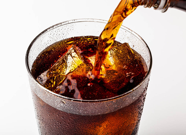 Ледяной освежающий газированный летний напиток с кусочками льда в стакане. - Фото, изображение